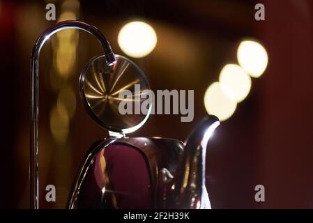 Gros plan d'un robinet et de la vapeur provenant d'une bouilloire sur un fond sombre avec espace de copie. Banque D'Images