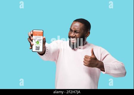 Passeport de vaccination pour COVID19 avec code QR affiché sur smartphone, dans la main d'un homme afro-américain. Vaccination, passeport d'immunité aux maladies, concept de soins de santé, nouvelles règles de voyage Banque D'Images