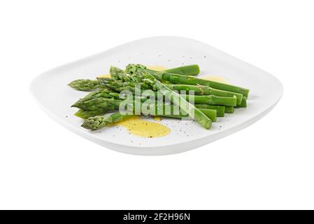 Asperges. Asperges vertes. Asperges bouillies fraîches sur plaque isolée sur blanc Banque D'Images