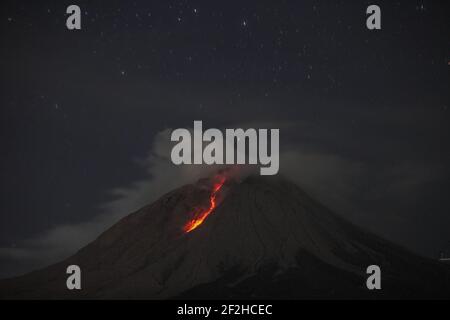 Sumatra Nord. 12 mars 2021. La photo prise le 12 mars 2021 montre des matériaux volcaniques et des fumées blanches qui se déversèrent du mont Sinabung, vues du village de Tigna Pancur à Karo, au nord de Sumatra, en Indonésie. Crédit: Alberth Damanik/Xinhua/Alamy Live News Banque D'Images