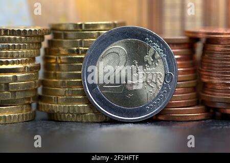 09.03.2021, une pièce de 2 euros devant une pile de pièces de cent supplémentaires sur une plaque d'ardoise. | utilisation dans le monde entier Banque D'Images