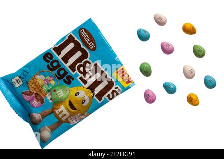 Paquet de chocolat d'oeufs M&M's ouvert avec contenu renversé ensemble sur fond blanc d'oeufs en chocolat M&M's. Banque D'Images