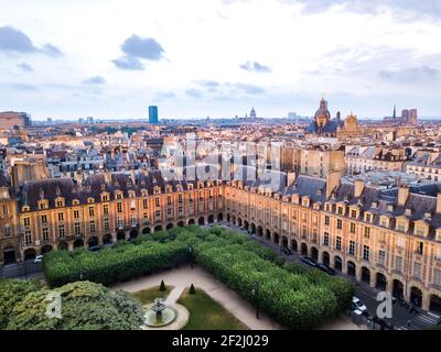 Vue aérienne sur la ville depuis la place des Vosges avec parc central et arbre au premier plan et bâtiments formant un paysage urbain en toile de fond. Banque D'Images