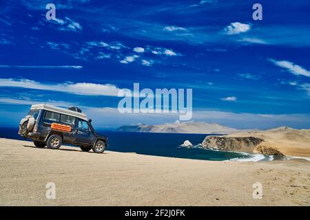 Desolate et vaste paysage de Paracas sur la côte du Pérou, un endroit où le désert rencontre l'océan. Ciel bleu, nuages et un désert de sable Banque D'Images