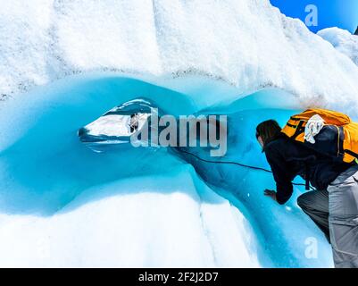 Randonneur se préparant à monter dans un tunnel de glace sur le glacier Fox, île du Sud, Nouvelle-Zélande. Adrénaline et aventure concept. Banque D'Images