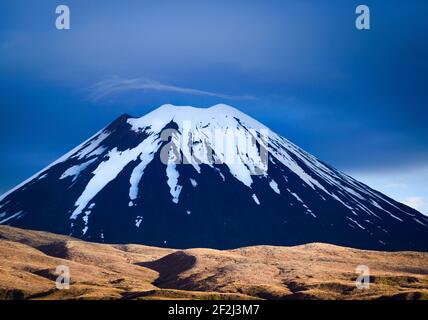 Vue agrandie d'un pic volcanique net recouvert de neige. Ciel sombre et nuageux. Traversée alpine de Tongariro, Nouvelle-Zélande. Banque D'Images