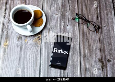 Un téléphone portable ou mobile posé sur un bois Avec l'application Forbes Magazine ouverte à l'écran Banque D'Images