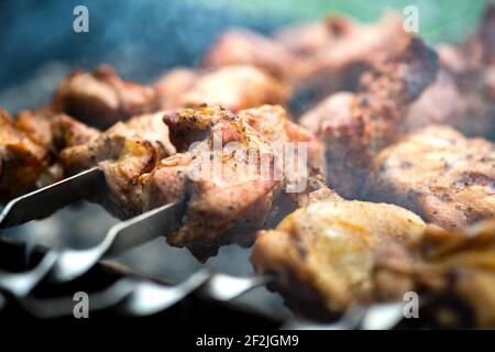 Shashlik ou shish kebab préparation sur barbecue grill sur charbon chaud. Morceaux de viande de porc grillés sur brochettes de métal. Banque D'Images