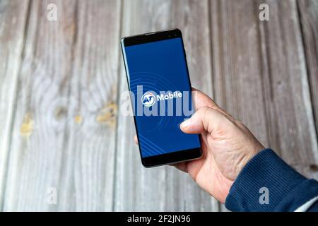 Un téléphone mobile ou mobile tenu dans un Main avec l'application AT Mobile ouverte à l'écran Banque D'Images