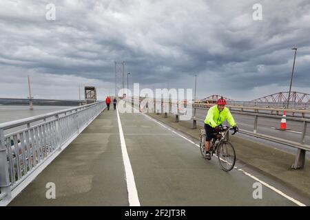 Cycliste traversant un vélo le pont de la quatrième route, Firth of Forth, Écosse, Royaume-Uni Banque D'Images