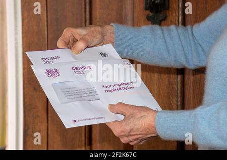 Angleterre, Royaume-Uni. 2021. Une femme âgée à sa porte d'entrée ouvre la documentation relative au recensement du Royaume-Uni que chaque résident de l'Angleterre et du pays de Galles doit faire Banque D'Images