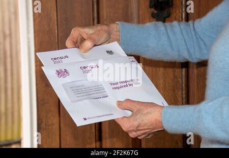 Angleterre, Royaume-Uni. 2021. Une femme âgée à sa porte d'entrée ouvre la documentation relative au recensement du Royaume-Uni que chaque résident de l'Angleterre et du pays de Galles doit faire Banque D'Images