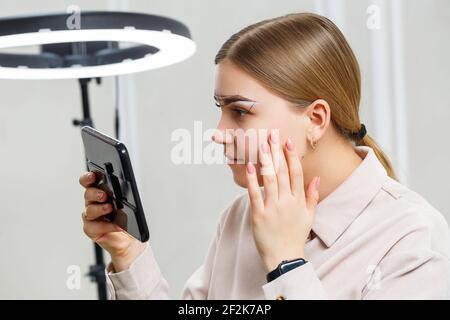 Maquilleuse applique la teinte des sourcils pour le maquillage permanent d'une jeune fille. Maquillage professionnel et soins cosmétiques pour le visage Banque D'Images