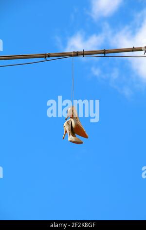 Vieilles chaussures pour femmes suspendues à un fil métallique Banque D'Images