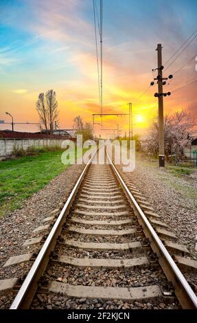 Les poteaux électriques sur une gare ferroviaire au lever du soleil Banque D'Images