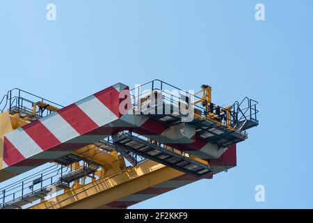 Concept mondial d'expédition et de cargaison: Vue sur un pont élévateur jaune debout à quai pour déplacer des conteneurs. Équipement de construction pour la logistique. Banque D'Images