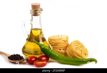 Les spaghettis crus nids, légumes frais et bouteille d'huile sur blanc arrière-plan Banque D'Images