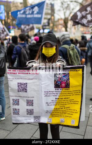 Un manifestant chinois tenant un écriteau lors d'une manifestation contre le Parti communiste de Chine, Leicester Square, Londres, 12 décembre 2020 Banque D'Images