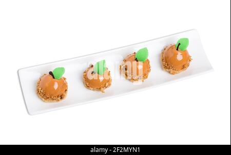 Délicieux gâteaux glacés au miroir au chocolat avec des feuilles de menthe en forme de poires. Isolé sur un fond blanc. Banque D'Images