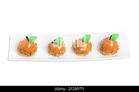 Délicieux gâteaux glacés au miroir au chocolat avec des feuilles de menthe en forme de poires. Isolé sur un fond blanc. Banque D'Images