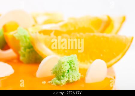 Éponge de siphon kiwi sur un gâteau glacé à l'orange. Macro. La photo peut être utilisée comme arrière-plan entier. Banque D'Images