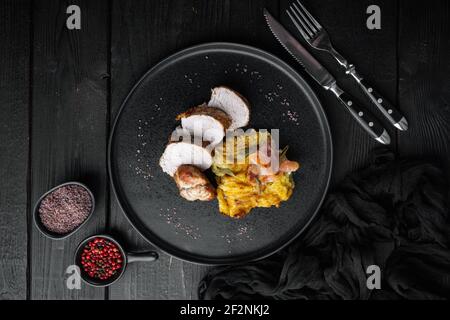 Filet de porc grillé et purée de pommes de terre gratin de potatoe avec ensemble de sauge et prosciutto, sur plat, sur fond de table en bois noir, sur le dessus de la table Banque D'Images