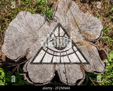Tous voyant des graffitis de l'œil sur le vieux arbre souche, l'état profond de la théorie du complot concept de société secrète Banque D'Images