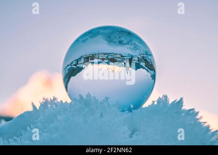 l'ancien village de vinigo vu à travers une boule de cristal reposant sur la neige gelée. Borca di cadore, province de belluno, dolomites, vénétie, italie Banque D'Images