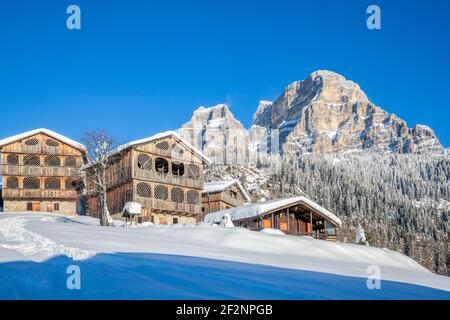 Maisons en bois rustiques traditionnelles dans le village de COI à Val di Zoldo, paysage enneigé avec le mont Pelmo derrière. Val di Zoldo, province de Belluno, Vénétie, Italie Banque D'Images