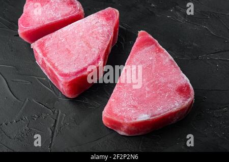 Ensemble de steaks de thon surgelé, sur fond de pierre noire Banque D'Images