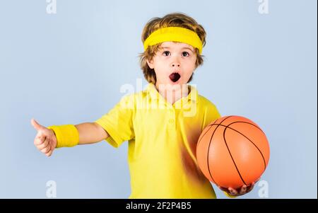 Les enfants et le sport. Petit ballon de basket-ball dans des vêtements de sport avec ballon. Petit garçon en uniforme de sport jouant au basket-ball. Banque D'Images