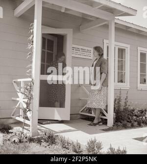 Tulare County, Farmersville, Californie. Camp de l'Administration de la sécurité agricole (FSA) pour les travailleurs agricoles migrateurs. Entrée à la clinique de l'Association médicale et de santé des travailleurs agricoles (AAS) pour l'aide de l'infirmière pour bébé malade. Une femme plus âgée dit: «Je suis juste un voisin et je me sens vraiment désolé pour eux». Mai 1939 . Photo de Dorothea Lange. Banque D'Images