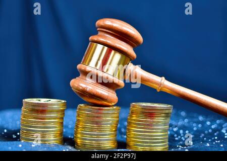 Trois piles de pièces d'or avec un gavel reposant sur les piles du milieu.le concept de la criminalité de col blanc Banque D'Images