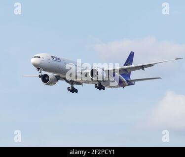 Londres, Heathrow Airport - Mars, 2020: Thai Airways Boeing 777 sur l'approche finale avec son train d'atterrissage vers le bas contre bleu clair ciel nuageux vu de Banque D'Images