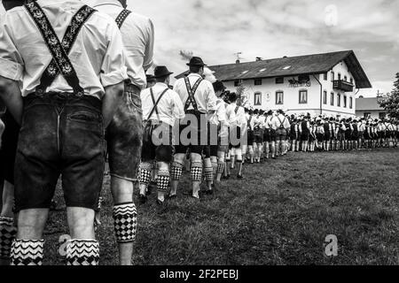 Allemagne, Bavière, Antdorf, semaine de fête de l'association traditionnelle de costumes. Des hommes en costume se tiennent sur un pré pour établir le record du monde de Schuhplattel. Banque D'Images