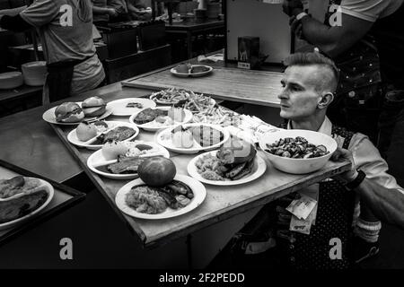 Allemagne, Bavière, Antdorf, semaine du festival du club traditionnel de costumes. Serveuse masculine avec divers plats sur le plateau Banque D'Images