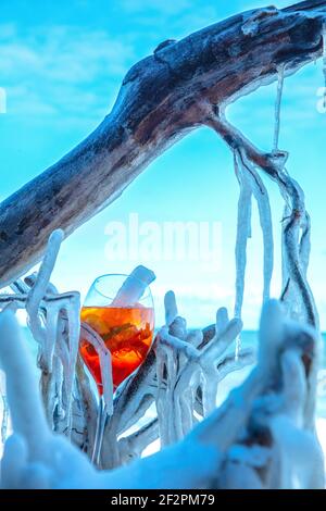 Aperol Spritz ou Sprizz est une boisson mélangée avec du vin blanc et de l'eau minérale et des agrumes. La boisson est servie sur la plage glacée de la mer Baltique. Banque D'Images