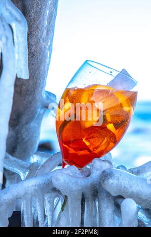 Aperol Spritz ou Sprizz est une boisson mélangée avec du vin blanc et de l'eau minérale et des agrumes. La boisson est servie sur la plage glacée de la mer Baltique. Banque D'Images