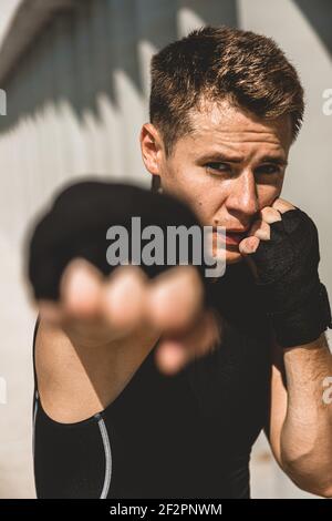 Homme s'exerçant et se battant à l'extérieur, boxeur en gants. Portrait de boxeur masculin Banque D'Images