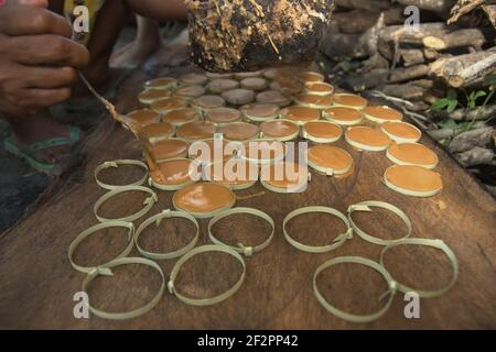 Une femme qui fait du sucre de palme dans le village d'Oehandi, île de Rote, Indonésie. Banque D'Images