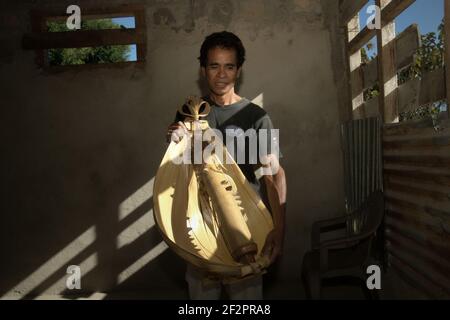 Hance PAH posant pour une photo avec un sasando électrique, l'instrument de musique à cordes traditionnel de l'île de Rote qu'il a créé, dans sa maison dans le village de Lalu Koen, île de Rote, est Nusa Tenggara, Indonésie. Banque D'Images