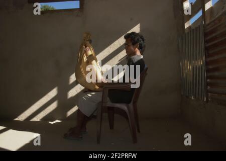 Hance PAH posant pour une photo avec un sasando électrique, l'instrument de musique à cordes traditionnel de l'île de Rote qu'il a créé, dans sa maison dans le village de Lalu Koen, île de Rote, est Nusa Tenggara, Indonésie. Banque D'Images