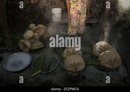 Une femme qui fait bouillir la sève du palmier pour faire du sucre de palmier, une autre source de revenu pour les villageois vivant à l'île de Rote, en Indonésie. Banque D'Images