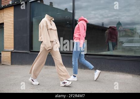Vêtements femme vides marcher dans la rue porter un sweat à capuche, un Jean, des baskets et des baskets colorées Banque D'Images