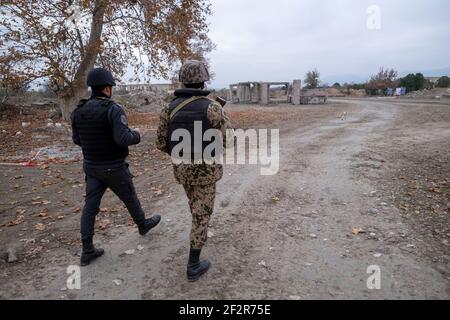 AGDAM, AZERBAÏDJAN - DÉCEMBRE 14 : des militaires azerbaïdjanais se promèrant dans des bâtiments en ruines de la ville d'Agdam qui a été détruite par les forces arméniennes lors de la première guerre du Haut-Karabakh le 14 décembre 2020 à Agdam, en Azerbaïdjan. La ville et son district avoisinant ont été retournés sous contrôle azerbaïdjanais dans le cadre d'un accord qui a mis fin à la guerre du Haut-Karabakh de 2020. Banque D'Images