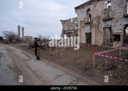 AGDAM, AZERBAÏDJAN - DÉCEMBRE 14 : des militaires azerbaïdjanais qui s'intéressent à un bâtiment en ruines dans la ville d'Agdam qui a été détruit par les forces arméniennes lors de la première guerre du Haut-Karabakh le 14 décembre 2020 à Agdam, en Azerbaïdjan. La ville et son district avoisinant ont été retournés sous contrôle azerbaïdjanais dans le cadre d'un accord qui a mis fin à la guerre du Haut-Karabakh de 2020. Banque D'Images