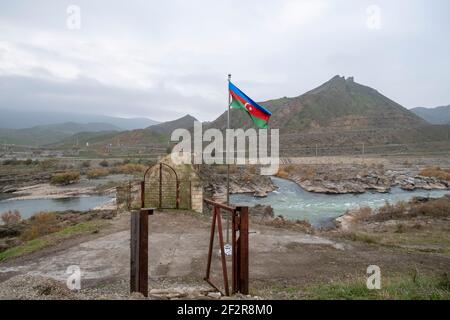 JABRAYIL, AZERBAÏDJAN - DÉCEMBRE 15 : drapeau national azerbaïdjanais placé du côté azéri du pont de l'arche Khodaafarin datant du 13th siècle reliant les rives nord et sud de l'Aras, situé à la frontière entre l'Azerbaïdjan et l'Iran, le 15 décembre 2020.Khoda Afarin borde un territoire contrôlé par les autorités arméniennes de souche en Azerbaïdjan, à proximité du Haut-Karabakh, qui a été ramené sous le contrôle de l'Azerbaïdjan dans le cadre d'un accord qui a mis fin à la guerre du Haut-Karabakh en 2020. Banque D'Images