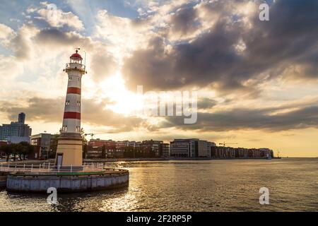 Phare rouge et blanc dans le port urbain de Malmö Suède pendant le coucher du soleil d'été Banque D'Images