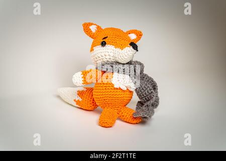 Orange renard Amigurumi avec écharpe en laine de Bavière Banque D'Images