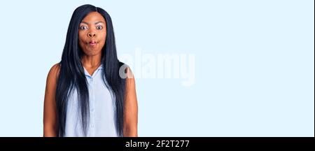 Jeune femme afro-américaine portant des vêtements décontractés faisant le visage de poisson avec des lèvres, fou et comique geste. Expression drôle. Banque D'Images